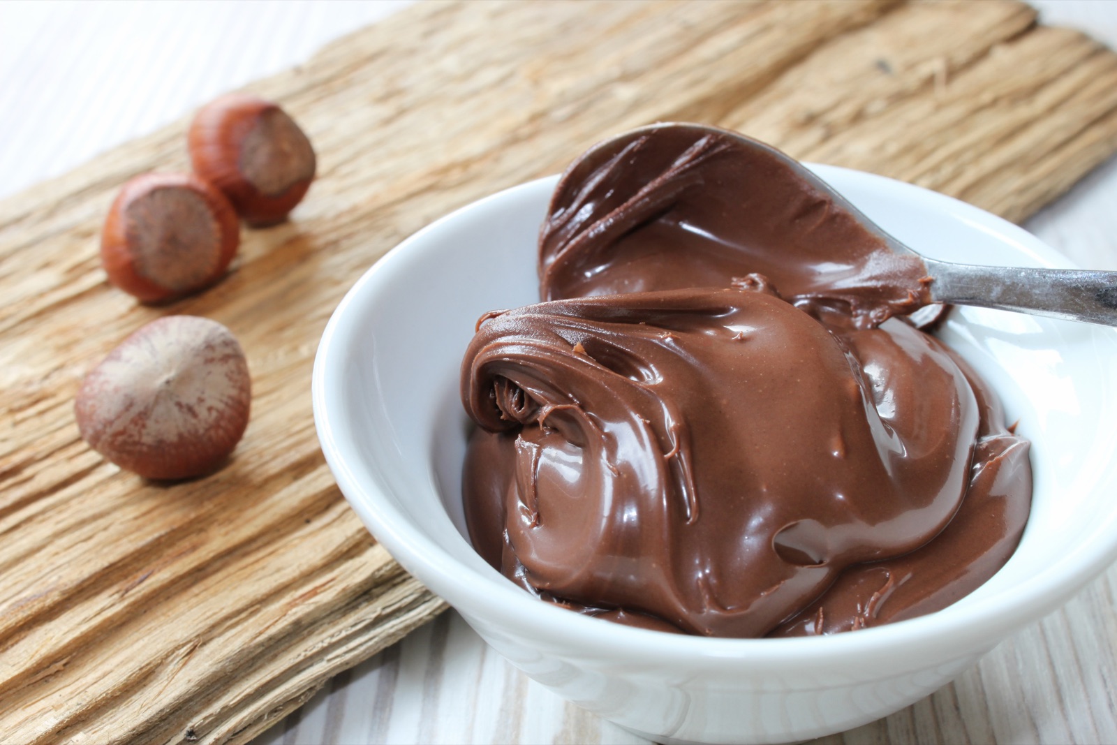 Crema de cacao y avellanas con el fruto seco al lado