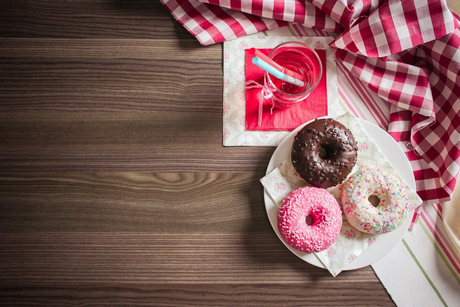 Varios donuts glaseados iguales sobre una mesa de madera