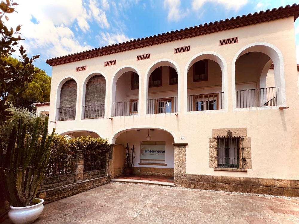 Fachada con galería de arcos de la oficina de Sant Cugat del Vallès, con el rótulo de Sensory Value en la entrada